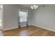 Empty dining room showcasing hardwood floors, modern light fixture, and view to front yard at 2234 Burgundy Way, Plainfield, IN 46168