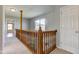 Second-floor hallway showcasing wood railings and a view from the window in a brightly lit space at 2234 Burgundy Way, Plainfield, IN 46168