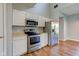 Modern kitchen with white cabinets, stainless steel appliances, and hardwood flooring at 2234 Burgundy Way, Plainfield, IN 46168