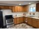 Functional kitchen with stainless steel appliances, wood cabinets, a double sink, and a window at 2608 S Rybolt Ave, Indianapolis, IN 46241