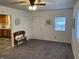 Cozy living room with a ceiling fan, neutral walls, plush carpet, and entry to kitchen at 2608 S Rybolt Ave, Indianapolis, IN 46241