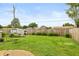 Spacious backyard featuring a lush lawn, wood fence, shed and mature trees at 2704 13Th St, Columbus, IN 47201