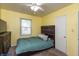 Small bedroom with yellow walls, ceiling fan, and a window letting in natural light at 2704 13Th St, Columbus, IN 47201