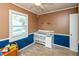 Bedroom featuring two-tone walls, ceiling fan, and a crib with changing table attached at 2704 13Th St, Columbus, IN 47201