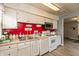 Well-lit kitchen featuring white cabinets, red accent wall, laminate floors, and ample counter space at 2704 13Th St, Columbus, IN 47201