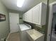 Laundry room with white cabinets, appliances, and a convenient utility sink at 2916 Wind Chime Cir, Greenwood, IN 46143