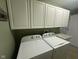 Laundry area with white appliances and plenty of overhead storage cabinets at 2916 Wind Chime Cir, Greenwood, IN 46143
