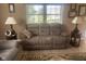 Cozy living room with a comfortable three-seater sofa, complemented by two lamps and natural light from the window at 2916 Wind Chime Cir, Greenwood, IN 46143