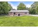 Expansive backyard featuring a brick home, lush lawn, and an inviting outdoor patio at 312 W Clark Ln, Fairland, IN 46126