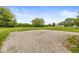 Expansive backyard featuring a large grass lawn, mature trees, and a gravel parking area at 312 W Clark Ln, Fairland, IN 46126