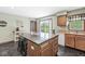 Well-lit kitchen featuring an island with seating, ample counter space, and a view of the serene backyard at 312 W Clark Ln, Fairland, IN 46126