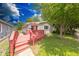 Charming home featuring a red deck and lush green yard with mature trees at 3220 Newton Ave, Indianapolis, IN 46201