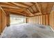 Unfinished garage ready for customization with exposed wood beams and a partially open garage door at 3220 Newton Ave, Indianapolis, IN 46201