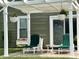 Outdoor seating area with hanging plants on a stamped concrete patio with green house in the background at 3404 Maritime Dr, Indianapolis, IN 46214