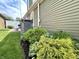 Side view of an exterior with green vinyl siding, surrounded by green shrubs and well maintained grass at 3404 Maritime Dr, Indianapolis, IN 46214