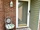 Inviting front door entrance with brick facade, decorative lantern, white chair, and colorful welcome mat at 3404 Maritime Dr, Indianapolis, IN 46214