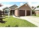 Charming brick home with an attached two-car garage, well-manicured lawn, and lovely landscaping at 3404 Maritime Dr, Indianapolis, IN 46214
