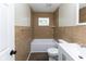 This bathroom features tile walls, a shower and bathtub combination, a small window and modern fixtures at 3614 N Whittier Pl, Indianapolis, IN 46218