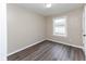This is a simple bedroom featuring hardwood floors, base trim and a single window letting in natural light at 3614 N Whittier Pl, Indianapolis, IN 46218