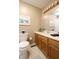 Bathroom with a wood vanity, framed art and an adjacent toilet at 3645 Richland Dr, Columbus, IN 47203