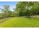 Lush backyard featuring a well-maintained lawn, mature trees, and play equipment at 3713 Coventry Way, Carmel, IN 46033