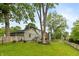 Landscaped backyard featuring lush greenery, mature trees, and a charming picket fence at 3713 Coventry Way, Carmel, IN 46033