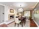 Dining room featuring a fireplace, hardwood floors, and a modern chandelier at 3713 Coventry Way, Carmel, IN 46033