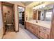 Bright bathroom featuring a wooden vanity and a doorway leading to a walk-in closet for ample storage at 3819 S Village Dr, New Palestine, IN 46163