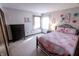 This is an image of the well lit bedroom featuring a metal bed frame and large window at 3819 S Village Dr, New Palestine, IN 46163