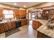 Open kitchen layout with stone countertops, stainless steel dishwasher, and a view into the dining room at 3819 S Village Dr, New Palestine, IN 46163