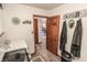 Hallway featuring an open laundry room, decorated walls, tile floors, and a closed door at 3819 S Village Dr, New Palestine, IN 46163