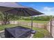 A well-kept backyard features a large patio umbrella and a charming hanging swing with a wood fence perimeter at 4167 Apple Creek Dr, Indianapolis, IN 46235