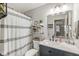 Stylish bathroom features a modern vanity, elegant mirror, and shower with patterned curtain at 4167 Apple Creek Dr, Indianapolis, IN 46235