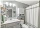 Well-lit bathroom with vanity, marble countertop and shower with patterned curtain for added privacy at 4167 Apple Creek Dr, Indianapolis, IN 46235