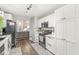 Well-lit kitchen with white cabinets, stainless steel appliances, and modern countertops, seamlessly connected to the living area at 4167 Apple Creek Dr, Indianapolis, IN 46235