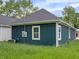 Side view of the home features a dark siding, white trim, and a well-maintained yard at 4230 Kingsley Dr, Indianapolis, IN 46205