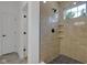Modern tiled shower with glass door and built-in shelving, complemented by hexagon tiles at 4234 Kingsley Dr, Indianapolis, IN 46205