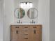 Elegant bathroom featuring double vanities, round mirrors, and modern lighting at 4234 Kingsley Dr, Indianapolis, IN 46205