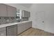 Modern kitchen with stainless steel appliances, gray cabinets, and black and white tile backsplash at 4234 Kingsley Dr, Indianapolis, IN 46205