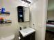 A bathroom with a vanity, mirror, shelves, and lighting, all neatly arranged at 4625 Woodcrest Dr, Columbus, IN 47203