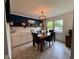 Stylish dining room with tiled flooring, white cabinets, a dark accent wall, and modern lighting at 4625 Woodcrest Dr, Columbus, IN 47203