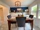 Beautiful dining room with tiled flooring, white cabinets, a dark accent wall, and modern chandelier at 4625 Woodcrest Dr, Columbus, IN 47203