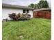 Exterior view of the house, featuring a white brick wall and bright bushes at 4625 Woodcrest Dr, Columbus, IN 47203