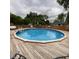 Relax by the in-ground pool surrounded by a wooden deck and mature trees at 4625 Woodcrest Dr, Columbus, IN 47203