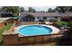 Outdoor pool with wooden deck, furniture, and a sunroom for relaxation and fun at 4625 Woodcrest Dr, Columbus, IN 47203