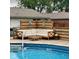 A poolside seating area with comfortable sectional and table, enclosed by a privacy fence at 4625 Woodcrest Dr, Columbus, IN 47203