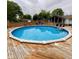Enjoy the in-ground pool surrounded by mature trees and a wooden fence at 4625 Woodcrest Dr, Columbus, IN 47203