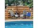 Poolside lounge chairs offer a relaxing space to soak up the sun, with a wooden privacy fence backdrop at 4625 Woodcrest Dr, Columbus, IN 47203