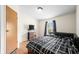 Comfortable bedroom featuring a modern black bedspread, wood-look flooring, and a bright window at 4640 Autumn Ridge Dr, Columbus, IN 47203