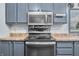 Modern kitchen featuring grey cabinets, stainless steel appliances, and speckled countertops at 4640 Autumn Ridge Dr, Columbus, IN 47203